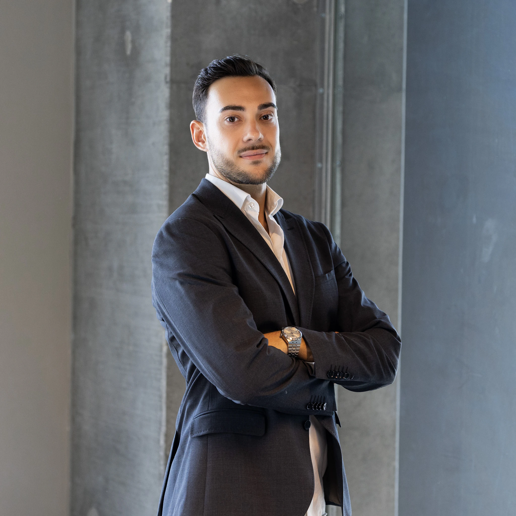 a man in a suit standing with his arms crossed